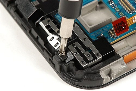 　5個のコネクタすべてを取り外したら、メインPCBをディスプレイアセンブリとフレームに固定している7本のプラスねじを取り外す必要がある。