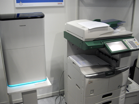 　東芝ブースでは、用紙を再利用する複合機システムを展示。右がプリンタやファクスなどの機能を備えた複合機。プリントした紙を左の機械に入れると熱処理により、プリントしたインクを消すことができるという。その際取り込んだ紙の内容はデジタルデータとして保存される。