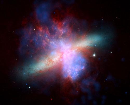 　この画像は、Hubble宇宙望遠鏡、Chandra X線観測衛星、Spitzer宇宙望遠鏡からの画像を複合したものだ。青色に見えるのがChandraで記録されたX線データ、赤色に見えるのがSpitzerで記録された赤外線、オレンジ色に見えるのがHubbleで観測された水素放射だ。