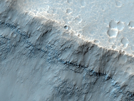 　でこぼこの露出部と浸食された衝突クレーターが、火星赤道近くにあるパロスクレーター（Palos Crater）の地表に並ぶ。
