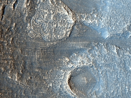 　この写真は、火星の北半球にあるデューテロニラスメンサ（Deuteronilus Mensae）地域の地形を撮影したものだ。NASAによると、この地域の特徴は、氷を多く含むと思われる「Lobate Debris Aprons」に囲まれたメサがあることだという。

　これは岩氷河、地塊運動、あるいは岩屑に覆われた氷河の流れといったさまざまな特徴によって成り立っている可能性がある、とNASAは話す。最新のレーダーデータは、Lobate Debris Apronsがほぼ純粋な氷でできていることを示している。このHiRISE写真に写っているのは、こうしたメサの端にある場所で、Lobate Debris Apronsが地盤から伸びている。