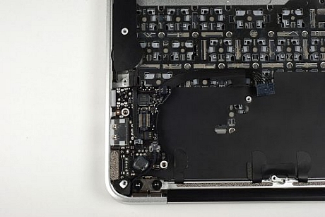 　MacBook Airのメインロジックボードまわりは調べたので、再びケースに注意を向けよう。ケースの左側には小さな回路基板があり、そこにはMagSafe電源ポート、USBポート、ヘッドフォンジャックがある。この回路基板は、3本のケーブルで、ケースのほかのコンポーネントと接続されている。この回路基板をケースから持ち上げる前に、そのケーブルをすべて外す必要がある。