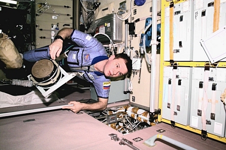 　無重力状態でZvezdaサービスモジュール内の廊下を進む宇宙飛行士のYuri Gidzenko氏。ISSシステムの定期メンテナンス作業中に、換気ファンを運んでいる。