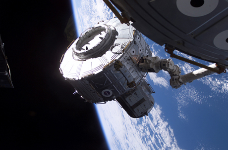 　2001年7月、Canadarm2ロボットアームを使ってQuestエアロックがUnityモジュールに取り付けられている。この写真が撮影された時、ISSの高度は地表から約237マイル（約380km）だった。