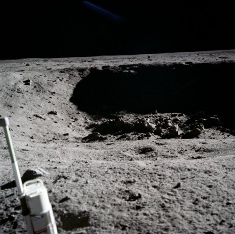 　月着陸船の近くにあった名前の付けられていないクレーター。ここでも、手前に見える物体は35mmのステレオクローズアップカメラ。Aldrin氏は次のように語った。「（われわれが）月面に着陸すると、すぐにちりが収まって、月着陸船を取り囲むすばらしい眺望が目に入った。クレーターの表面が見えた。大きなものは15フィート（約4.57m）、20フィート（約6.10m）、30フィート（約9.14m）まで、小さなものは直径1フィート（約30cm）まで、多数のクレーターであばたのようだった。当然ながら、月面は非常にきめの細かい表面だった。驚くほど多くのさまざまな大きさの岩石があった」