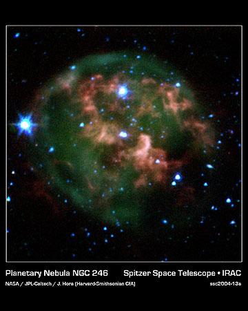 　NASAのSpitzer宇宙望遠鏡からのこの着色像には、燃えるようなガスとちりの雲で囲まれた死にかけた星（中央）が写っている。新たな画像では、Spitzerのちりを突き抜ける赤外線カメラにより、雲の中心部から少し離れた物質の巨大な輪という、これまで見たこともない特徴もはっきりととらえられている。この塊状の輪は、年老いた星から放出された物質で構成されている。
