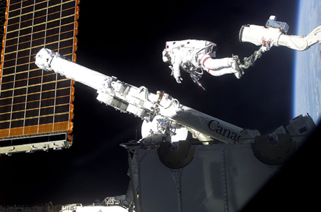 　Canadarm2ロボットアームに接近しようとしているカナダ宇宙庁のミッションスペシャリストChris Hadfield氏。この写真はCanadarm2が取り付けられた日に撮影されたものだ。同氏が立っている（また固定されている）のは、スペースシャトルに取り付けられたロボットアーム（NASAの用語では「リモートマニピュレータシステム」）のフットレストレイント（足部固定具）である。