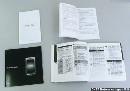 　PRADA Phoneには使い方を詳しくまとめた取扱説明書が付いている（下）。アイコンやイラストが多用され、分かりやすい。一方のiPhoneは「この製品についての重要なお知らせ」という薄い冊子（上）が入っているだけで、文字が細かく読みにくい。