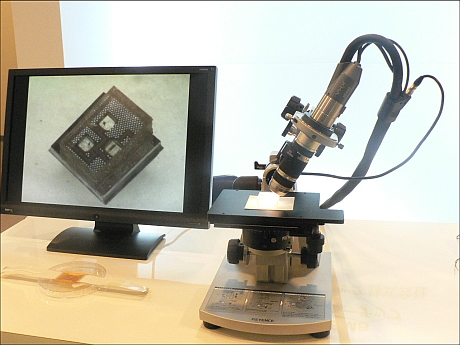こちらも優秀賞の東京大学、パナソニックによる「超小型MEMS 3軸触覚センサーチップ」。米粒の半分程度のサイズのチップの中に、圧力センサー、2軸のせん断力センサーが組み込まれている。あまりの小ささのため、顕微鏡に写されて展示されている。