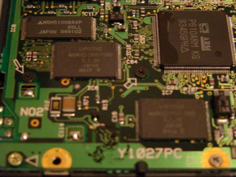 　写真の2つの同型のチップ（CPUの下と左下）は、NewtonのシステムROM。4MバイトのオンボードROMで、カレンダー、電卓などのNewtonプログラムを格納している。左上隅のチップは、他のチップのパリティチェックに使われるRAMチップ。