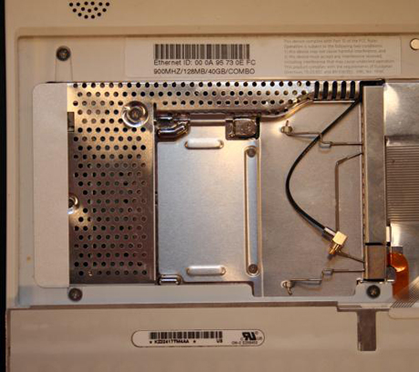 　このiBookに「AirMac」（ワイヤレス）カードが装備されていれば、ここに取り付けられていたはずだ。アンテナケーブル（先端部が銀と金の黒いケーブル）があるのがわかる。また、RAMシールド（システムに装着された追加RAMを保護する銀色のケージ）も見える（拡張ベイはこのシールドの向こう側にある）。
