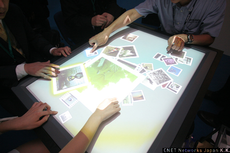 三菱電機のブースで展示されていた、「マルチユーザー・タッチテーブル」。画面をタッチし、指で画像の拡大や移動などの操作が行える。複数人で同時に利用できるマルチユーザー対応が特徴