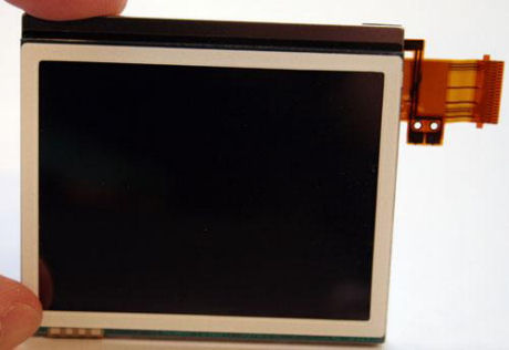 　この写真は、DS Liteのタッチスクリーン付き液晶ディスプレイだ。回路基板から外されたフラットケーブルが、ディスプレイの右側から伸びている。