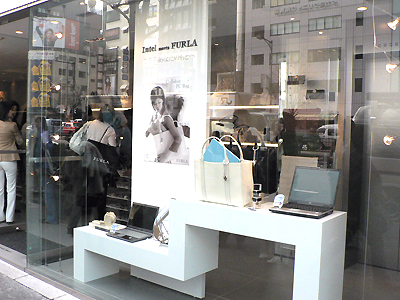 FURLA青山本店。ショーウィンドウ全面にPCバッグとノートPCが展示されている。
