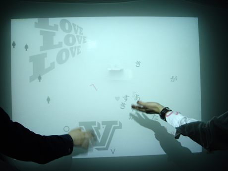来場者が直接作品作りに参加できるインタラクティブな出展も行われた。富士通×GK TECHブースの「Re：Shadowgraph Project」では、自分の影を動かすことで、スクリーン上の文字を動かしたり、色が着けられたりと1枚絵を作り上げることができる。