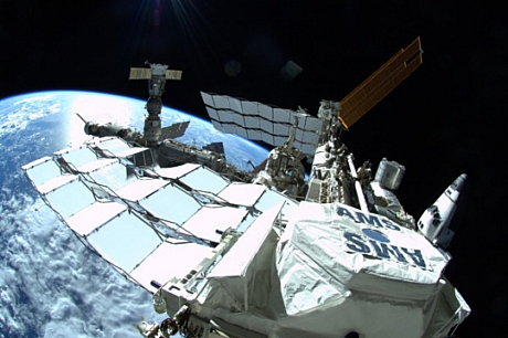 　米国時間7月12日の船外活動中に撮影されたこの写真には、ISSが前後方向に写っている。
