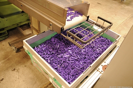 　金型で圧縮されたばかりの紫色のレゴブロックがたくさん容器に入っている。