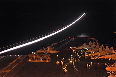 　同じく6月の夜間に撮影されたこの写真には、飛び立ったばかりの飛行機の光跡が写っている。そのそばでは、F/A-18E Super Hornet（先に紹介した第136戦闘攻撃飛行隊の戦闘機）がEnterpriseの2番カタパルトで発艦を待っている。