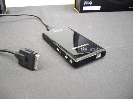 　米マイクロビジョンでは、iPod/iPhone/iPad専用のケーブルを同梱し、ケーブル1本で接続できるポータブルレーザープロジェクタ「SHOWWX＋ Laser Pico Projector」を7月に発売した。重量約122g。光源にレーザーを使用しているためピント合わせが不要だ。