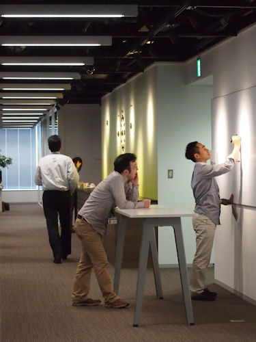 　壁際にはホワイトボードや少し高めのテーブルが並ぶ。これは立ってミーティングするためのスペース。

　社内の至る所にちょっとしたミーティングスペースを用意しているのも、新オフィスの特徴だという。