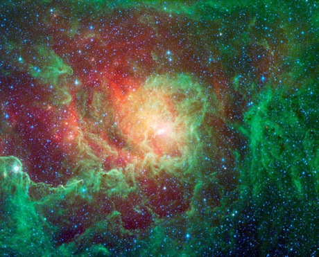 　「干潟星雲」は「M8」および「NGC 6523」としても知られている。この干潟星雲の写真では、渦巻くちりの雲と生まれたばかりの明るい星が見える。緑色は炭素が中心のちりで、赤い光はちりの中でも温度が最も高い部分だ。

　可視光では巨大な若い星をとりまく大量の高温のガスが見える。一方、同じ領域を赤外線で撮影すると、その高温ガスを透かして、ガスが満ちている領域のちりが見える。
