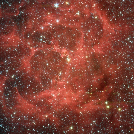 　IRACでは星が成熟していく様子を調べている。IRACは、恒星進化のプロセスがその周囲に与える影響を観測できる。この写真の「三裂星雲」には、進化のあらゆる段階の星が含まれており、周囲を取り囲むガスとちりが美しいバラ色の星雲を形成している。