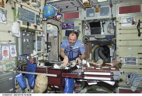 　米国の宇宙飛行士Scott Kelly氏とロシアの宇宙飛行士Mikhail Kornienko氏は現在、国際宇宙ステーション（ISS）で丸1年を過ごすための準備をしている。これは長期宇宙滞在が人間に与える影響について、米航空宇宙局（NASA）がより深い洞察を得るために行われるものであり、同時に今後数十年間のうちに行われる火星探査の下準備をするためのものだ。

　2015年に開始される予定の1年にわたるISS滞在ミッションでは、閉鎖された空間に暮らすという課題がKelly氏とKornienko氏に突きつけられることになる。食事や睡眠、エクササイズ、気晴らしといったことを、高度に技術的かつ窮屈な環境で行うことになる。

　それはどのような生活になるのだろうか。このフォトギャラリーでは、以前に撮影された、宇宙空間での生活の様子を見返すことで、それを考えてみたい。

　この写真では、宇宙飛行士のYury Usachev氏が、ISSの「Zvezda」サービスモジュール内のキッチンのような一角で食べ物を手にとっている。2001年7月16日撮影。
