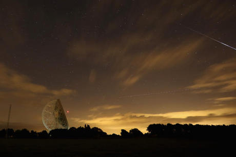 　13日に、イギリスのホルムズチャペルにあるジョドレルバンク天文台ラヴェル電波望遠鏡の上空を横切る、ペルセウス座流星群の流星痕と飛行機の長い光跡。