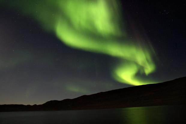 　グリーンランドのカンゲルルススアーク近くの湖の上に光るオーロラ・ボレアリス。