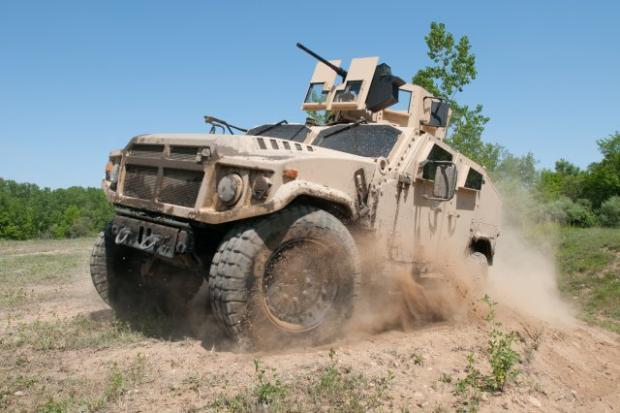 　米陸軍の統合軽戦術車両（Joint Light Tactical Vehicle：JLTV）プログラムにとって、2014年は研究開発の年になるだろう。路上テスト、オフロードテスト、メンテナンス評価、さらに、路上の爆発物が引き起こす被害の程度を調べる「ブラストイベント（blast event）」などが実施される。こうしたテストが、2015会計年度の契約獲得、2016会計年度の初号車の運用、そして2018会計年度の実戦部隊への編入に道を開くだろう。2013年9月までに、米陸軍は競合する防衛請負業者3社（Oshkosh Defense、Lockheed Martin、AM General）から22台のプロトタイプを納入されている。上の写真はAM Generalが設計した車両で、JLTVは、同社が製造するHumveeの後継となる。

　JLTVの機能の中でも特徴的なのは、オープンな「プラグアンドプレイ」の性質を持っていることだ。それにより、車両を再設計しなくても、将来のネットワーキング機器やそのほかの電子機器を取り付けることができる。