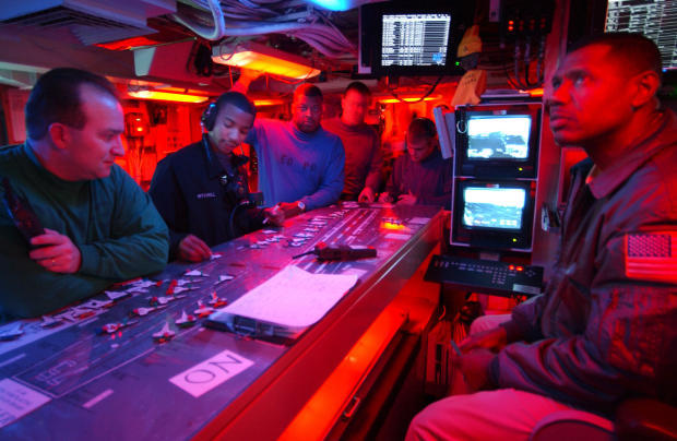 　2003年2月28日、洋上にある航空母艦「USS Harry S. Truman」の艦上で、「夜間離着艦作戦の間の飛行甲板管制展開」を行う水兵。米海軍によれば、同艦は「不朽の自由作戦」のために配備されているという。