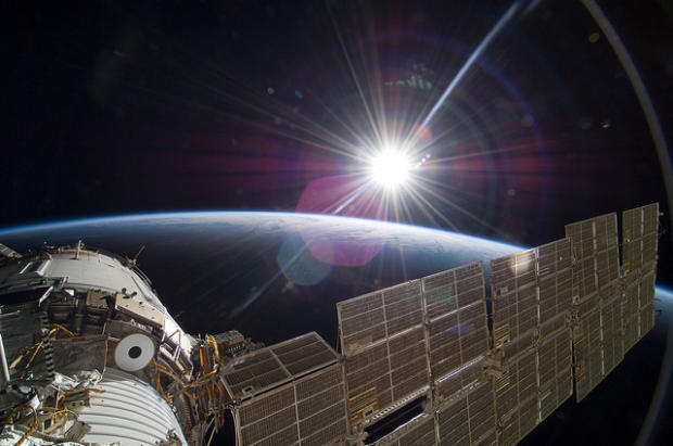 　2009年に撮影されたこの写真では、太陽が地球の地平線上に見えており、その光が国際宇宙ステーションに滞在中の宇宙飛行士らに届いている。