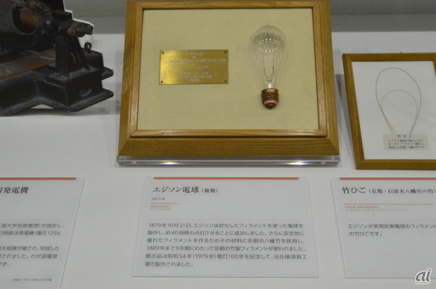 　2014年1月31日、ラゾーナ川崎東芝ビルに東芝未来科学館がオープンした。歴史資料展示のみならず、最新技術を誰もが予約なしで無料体験できるスポットだ。東芝の歴史と日本近代科学技術の歩みが見られる「ヒストリーゾーン」から、今回は電球を振り返る。なお、世界初、日本初の冷蔵庫やテレビなどを紹介した「家電・AV機器編」、なつかしのPC「J-3100」や世界初の日本語ワープロなどをまとめた「電子・コンピュータ編」も掲載している。

　写真は、エジソン電球。真空電球の実用化は1879年（明治12）英国のスワンと米国のエジソンがほぼ同時期に炭素電球を完成させた。エジソンは、木綿糸に「すす」を塗って蒸し焼きにしたフィラメントで、炭素電球の点灯に成功する。さらに長寿命化のフィラメント材料として、京都石清水八幡宮の竹を炭化して長時間の点灯に成功する。昭和54年（1979年）電灯100年を記念して、東芝横須賀工場で製作したエジソン電球のレプリカ。