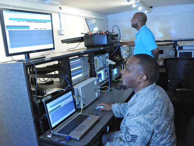 　RVの中で、米空軍の技術者2人がC-5機内のノートPCから送信される信号を監視している。