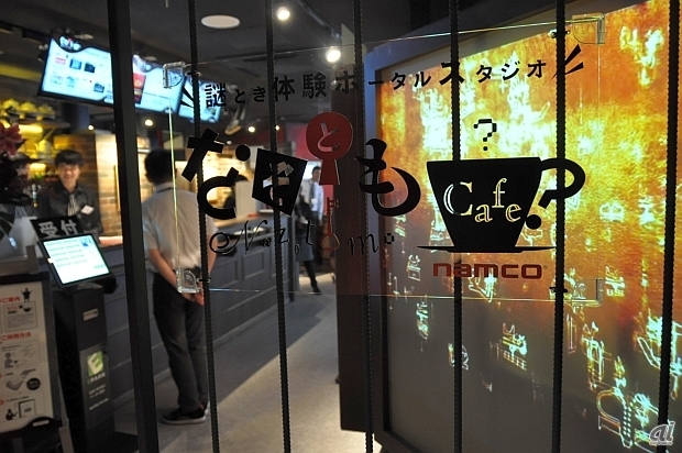 　ナムコは8月22日、東京都新宿区にあるドン.キホーテ新宿東口本店7階に、常設型の謎とき体験ポータルスタジオ「なぞとも cafe 新宿店」をオープンした。営業時間は月曜日から金曜日までが16時から23時、土日祝日が11時から23時まで。入場は施設の利用を前提として無料。メインとなるミッションキューブは1回につき税込1080円。

　この施設は、謎解きのリアルゲームを体験できる施設。参加予約が不要であったり、コンパクトな体験時間、コンテンツが選べることなどを特徴としている。

　同社では2012年秋から謎解きイベントの情報を集めたポータルサイト「なぞとも」を立ち上げ、2013年には代官山で「なぞとも cafe」を期間限定で営業した。今回のなぞとも cafe 新宿店については常設店舗として、リアルな情報発信と顧客接点を担う旗艦拠点に位置づけ、リアルゲーム分野への本格展開や「なぞとも」ブランドによる事業を推進するとしている。