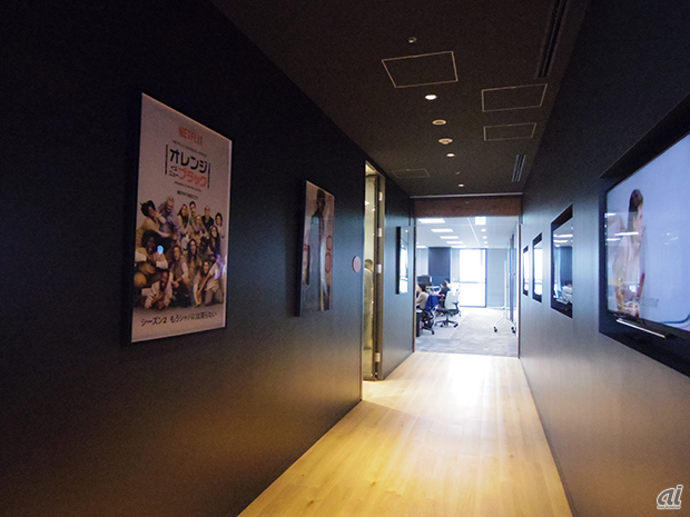 　オフィスへ続く壁には、オリジナルコンテンツのポスターと液晶テレビが埋め込まれており、コンテンツが流されていた。