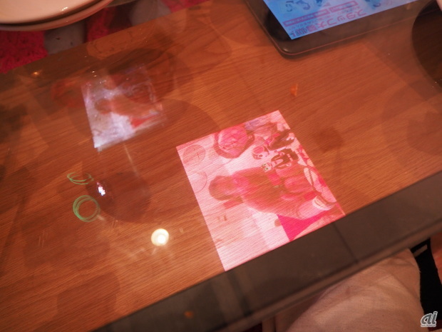 プロジェクタでガラスのテーブルに映したところ。意外とちゃんと見られる
