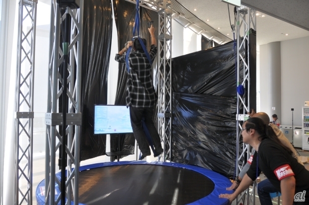 　ハシラスの「オムニジャンプ」。ゴムの力を使って高く飛べる装置を活用し、VR世界ではもう少し高く飛べる感覚を体験できるというもの。VR技術を身体の活性化やトレーニングに役立てる試みとしている。