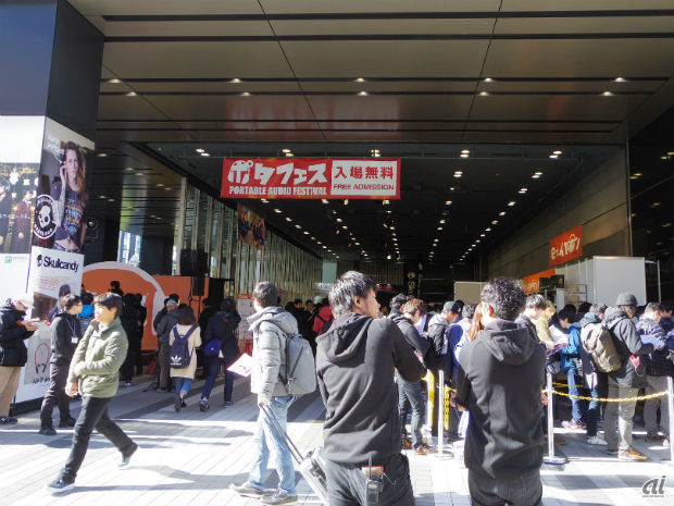 　ポータブルオーディオ専門店「e☆イヤホン」を運営するタイムマシンは、12月17～18日の2日間、東京・秋葉原のベルサール秋葉原にて、イヤホン、ヘッドホンのイベント「ポタフェス 2016」を開催している。開場は両日ともに11～18時。国内外の150以上のブランドが集う。入場は無料。

　会場はベルサール秋葉原のB1、1、2階の3フロアに加え、秋葉原UDXの2階にある「AKIBA＿SQUARE」も使用。各種ブランドブースで、新製品、参考出品などの視聴体験ができるほか、ライブイベントやVRは体験コーナーまでをそろえた、一大イベントになっている。

　写真は12月17日午前中のイベント会場前の様子。ｅ☆イヤホンの販売コーナーにビルの周りを半周するほど長い列ができたほか、ライブイベント中はステージ前に人垣ができた。
