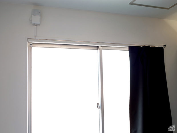 　窓の左上に設置されているのは、スマートホーム向けIoTサービス「ホームウォッチ」（大崎電気工業）。遠隔からスマートフォンで家電製品を制御したり、室内の環境状態を確認したり、さらにはドア・窓開閉センサにより外出時の異常を知らせるなど、スマートフォンから家の中を自由にコントロールできる。
