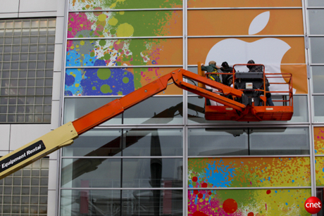 　Appleが米国時間1月27日にイベントを開催する会場外で、窓にクレーンから飾り付けをする作業員。