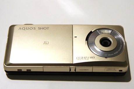 　2010年夏モデルの中でもハイエンドモデルとなるAQUOS SHOT 945SH。HDMI出力のほかにもカメラ機能が充実している。斜めから撮影した画像を正面から撮影したように加工できる「ショットメモカメラ」、あらかじめ登録した人物を撮影するとその画像を自動的に集めてアルバムを作成する「おまかせアルバム」機能などを持つ。