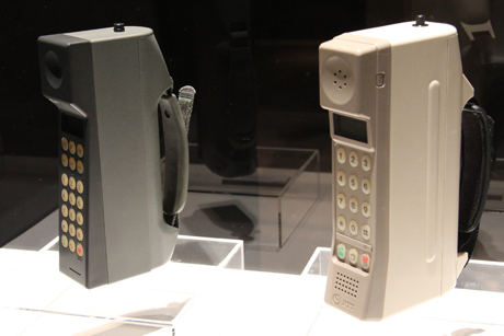 　それまでの自動車電話と違い、手に持てるサイズとして携帯電話が登場したのがちょうど1980年代後半。右が1987年に登場したTZ802B、左が1989年に登場した「TZ803B」。TZ802Bは、重さが750g、体積が500cc。現在では小型・軽量とはいえないが、当時は衝撃的な小型・軽量さだった。