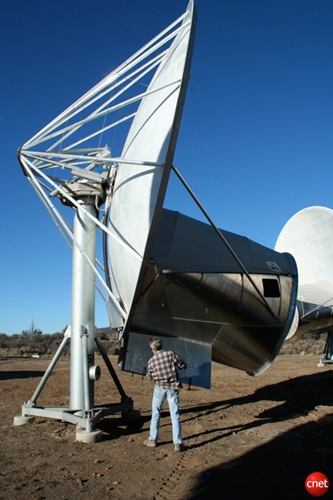 　アンテナを見ていても、その大きさを把握するのは難しい。この写真では、この天文台に常駐している天文学者Rick Forster氏がアンテナの傍らで、受信機を収納し風雨から保護するためのコンパートメントを開いている。このコンパートメントは、感度の高い受信機を地上の放射線から守る役目も果たしている。