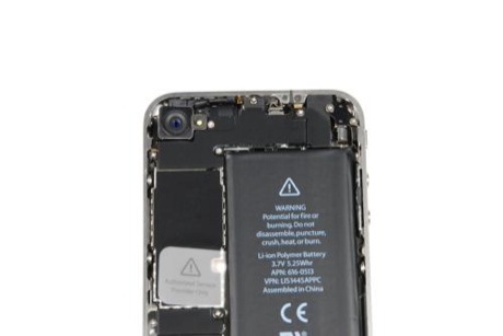 　iPhone 4の上部に背面カメラが見える。カメラの下にあるのは黒いEMIシールドで、メインロジックボードにあるいくつかのコネクタを覆っている。上部右隅には、小さい銀色のバイブレーションモーターがある。
