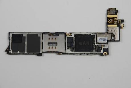 　iPhone 4のロジックボード上部から2つの金属シールドを取り外すと、ついにiPhone 4のメインチップを目にすることができる。2つの成型されたゴムのクッションが、ロジックボードの左側にあるチップを覆っている。