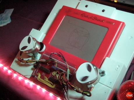 　James Delaney氏による「CNC Magic Screen Machine」は基本的には、ロボット操作のお絵かき板（Etch-a-Sketch）である。このデバイスは、コンピュータがお絵かき板に設置され、コンピュータにロードされたイメージをほとんど何でも自動で描画することができる。
