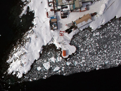 　アンバース島のパーマー基地で、米国南極プログラムのメンバーが赤いジャケットを着て、頭上を飛ぶアイスブリッジ調査の飛行機にあいさつの文字を描いた。パーマー基地は、人が極めて少ないこの大陸に3カ所ある米国の環境研究施設の1つだ。

　アンバース島は、南極半島のほぼ中間に位置している。南極半島は、ティエラ・デル・フエゴ島に向かって北に伸びており、その先には南米大陸の南端がある。アイスブリッジ調査チームの拠点があったのはその地域、チリの最南端プンタアレナスで、南極大陸の上ではなかった。