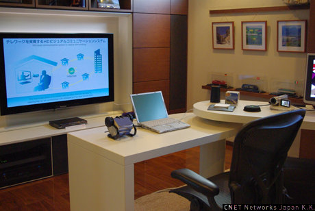 　「在宅勤務体験ラボ」では、自宅とオフィスをつなぐテレワークによるHDビジュアルコミュニケーションシステムを展示していた。ワークスタイルを多様化することで、移動によるCO2削減に寄与できるとのこと。
