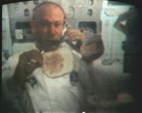 　7月22日のこの写真では、Aldrin氏が地球上のテレビの視聴者に対し、宇宙飛行士が無重力状態でいかにしてサンドイッチを作るかを見せている。